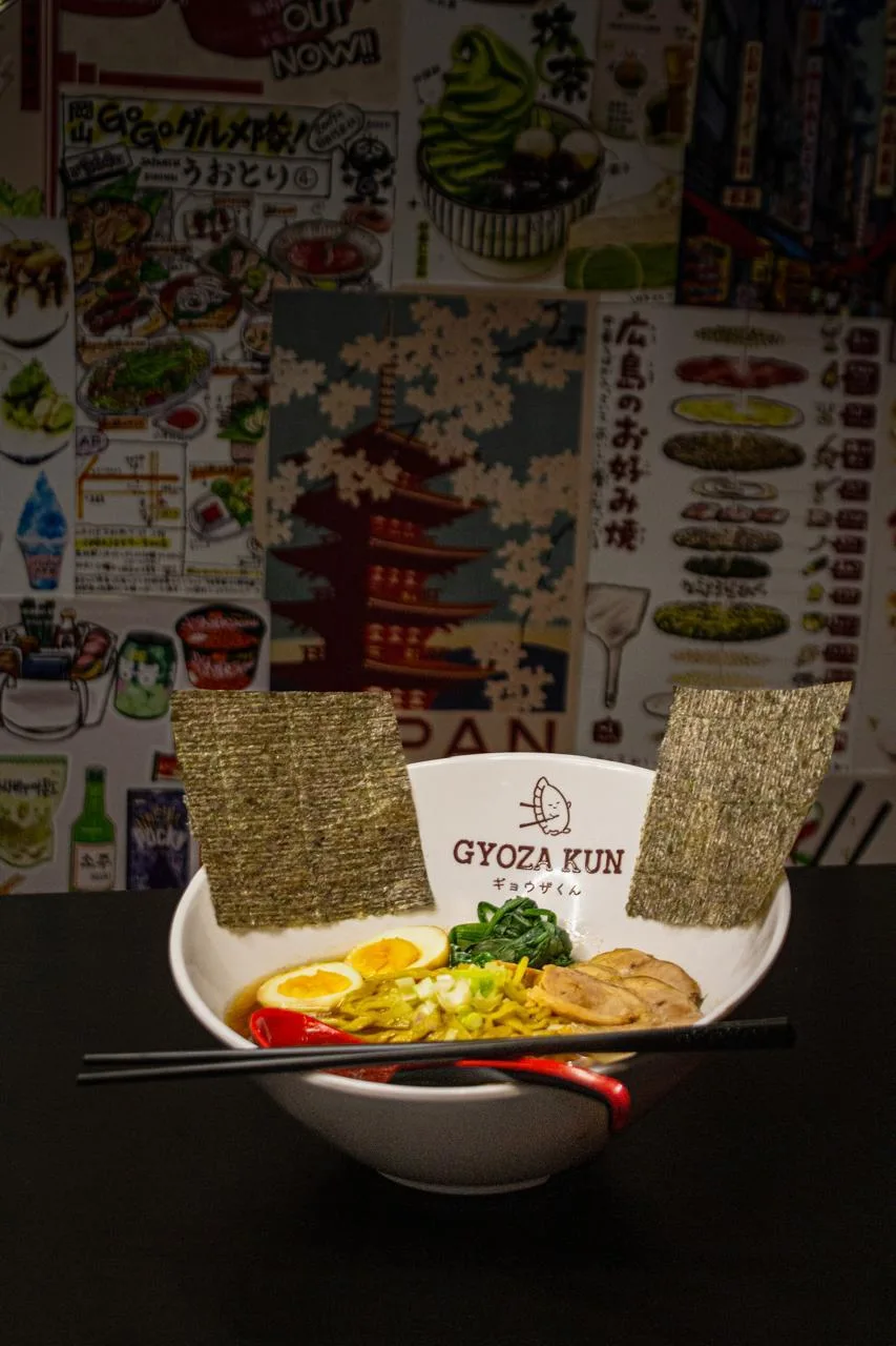 Ramen de la casa frente al muro de carteles japoneses del local